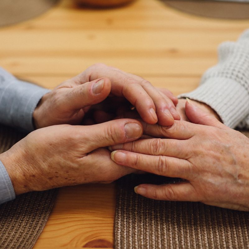 An older couple's hands held together.